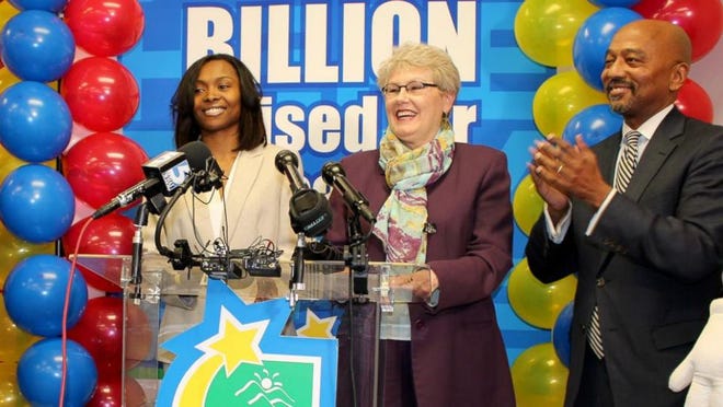 Marie Holmes claims a third o the $564 million Powerball jackpot