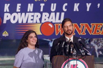 After receiving a ceremonial check at Louisville Slugger Museum, Powerball winner David Edwards, of Westwood, Ky., answered reporters' questions yesterday with fiancee Shawna Maddux at his side. They may move to Las Vegas or Florida.